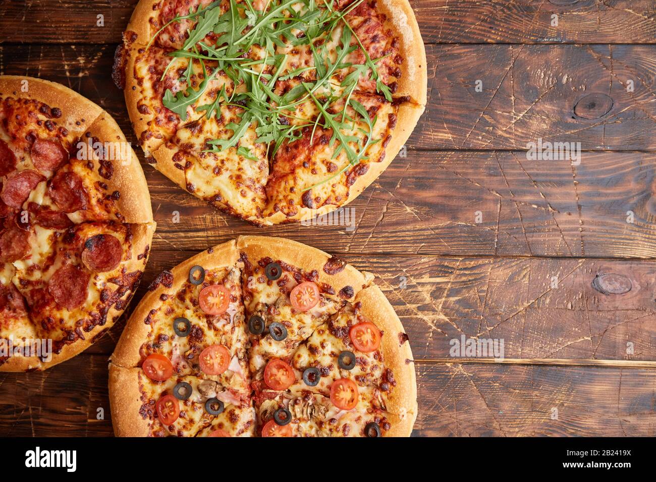 Composition de trois différentes sortes de pizzas sur table en bois Banque D'Images