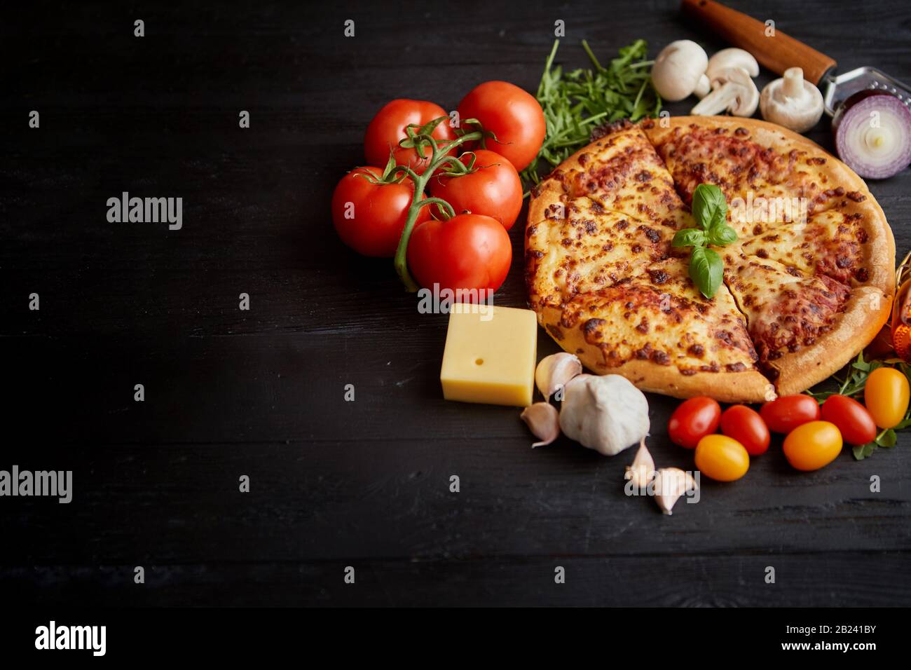 Pizza italien délicieux servi sur table en bois noir Banque D'Images