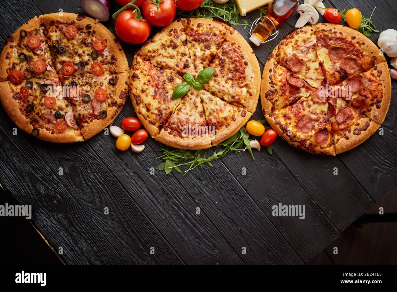 Servi frais, trois différentes pizzas placé parmi des ingrédients savoureux. Vue d'en haut Banque D'Images