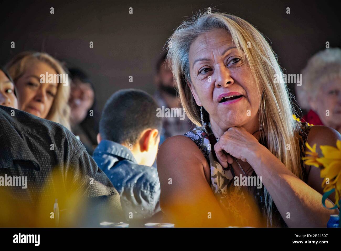 Une femme d'âge moyen qui parle et regarde ce qui se passe lors d'un vrai rassemblement familial Banque D'Images