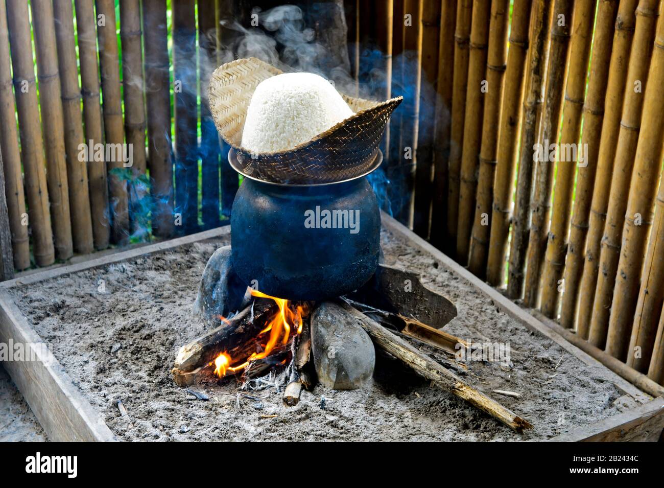 Cuiseur à riz traditionnel au feu ouvert, cuisson à base de riz collant  dans un panier de bambou au-dessus de l'eau de simmering, Farrm de riz  vivant à terre près de Luang