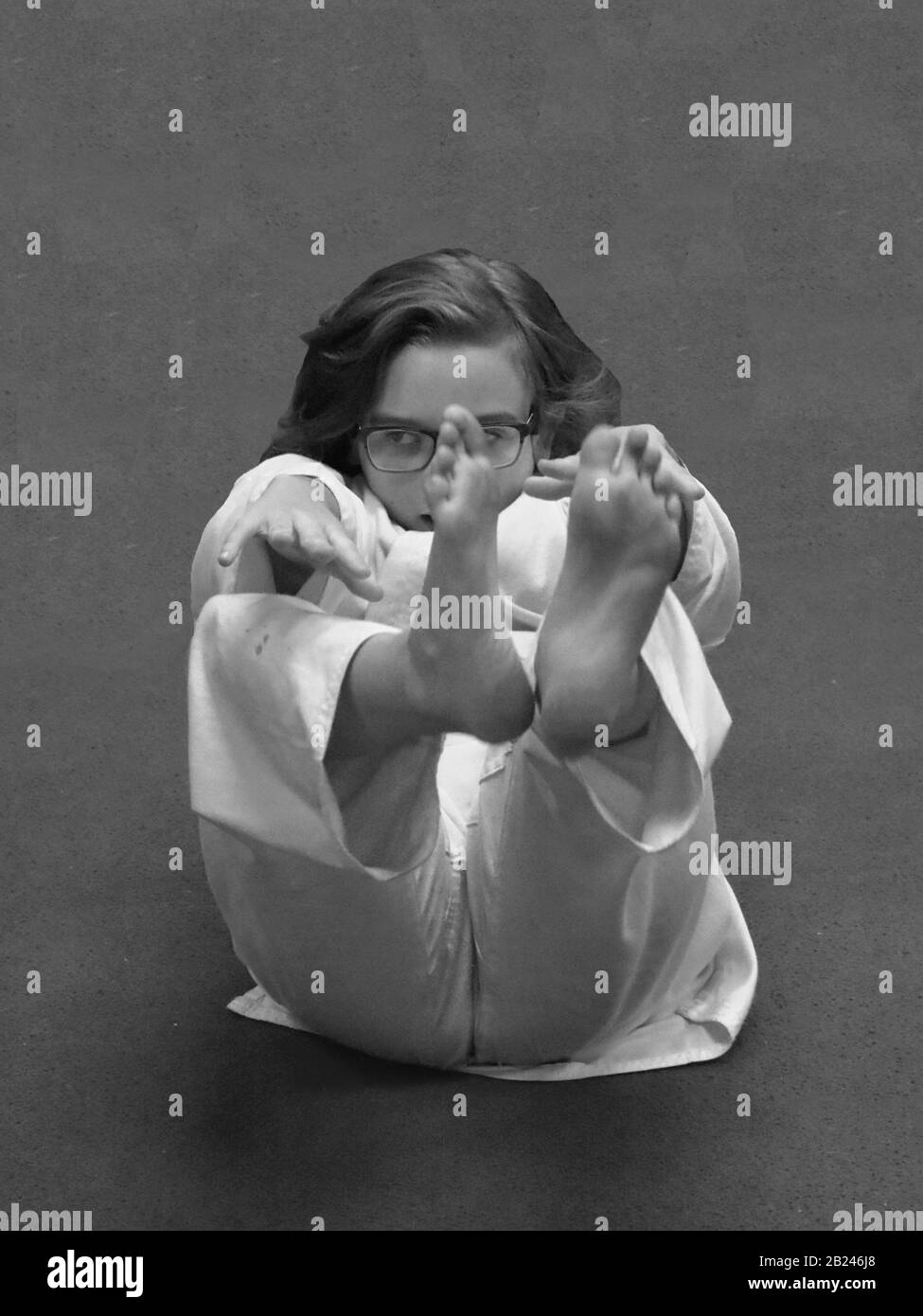 Ces photos d'action en monochrome et en couleur sont de ma fille faisant un exercice d'étirement dans sa classe de karaté. Les jambes et le dos sont dans l'air. Banque D'Images