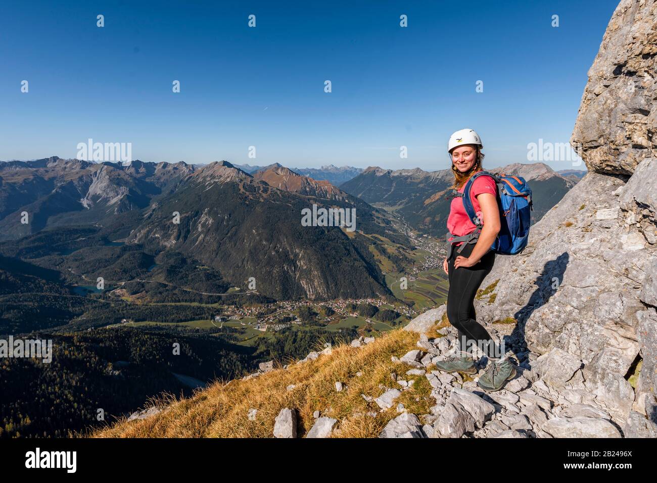 Jeune femme, alpiniste avec casque d'escalade regardant le paysage de montagne, randonnée à Ehrwalder Sonnenspitze, derrière Gruenstein et l'ouest Banque D'Images