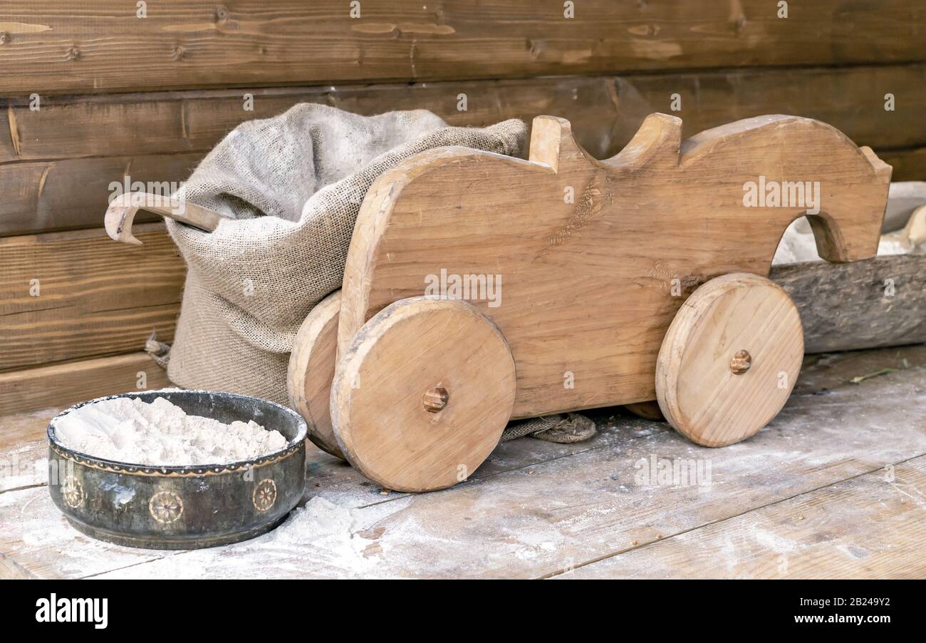 Sac avec farine, grille et vieux jouet en bois sur la table. Banque D'Images