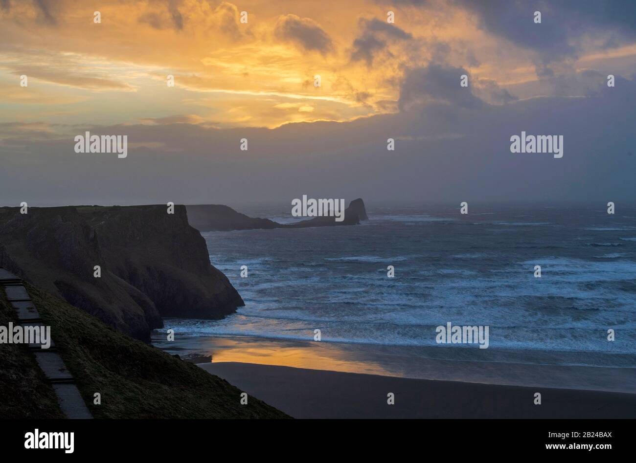 Rhossili, Gower Peninsula, Royaume-Uni, 29 février 2020 : un coucher de soleil très orageux au-dessus de Worms Head dans le petit village de Rhossili sur la péninsule de Gower près de Swansea alors que la tempête Jorge fait la terre ce soir. Banque D'Images