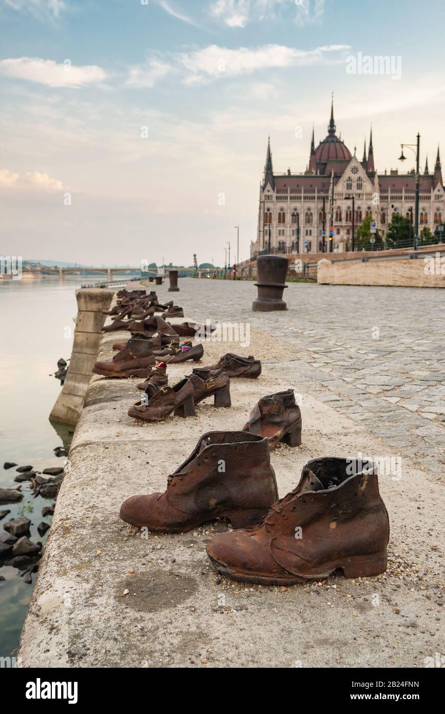Chaussures sur le mémorial de la Banque du Danube avec le bâtiment du  parlement de Budapest en arrière-plan Photo Stock - Alamy
