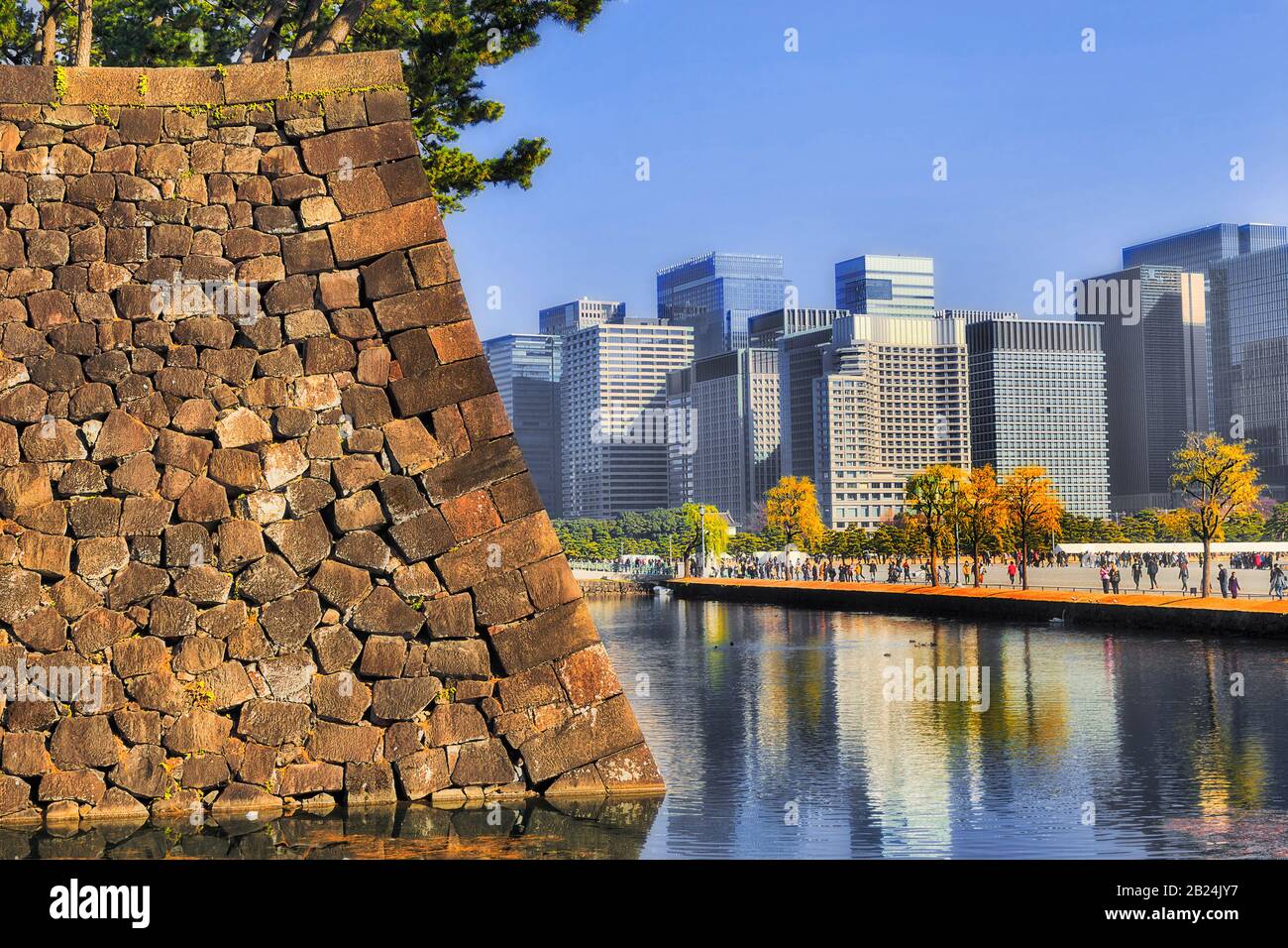 L'eau s'amarra autour de forts murs en pierre d'un parc et de jardins à Tokyo CBD une journée ensoleillée avec des foules de touristes. Banque D'Images