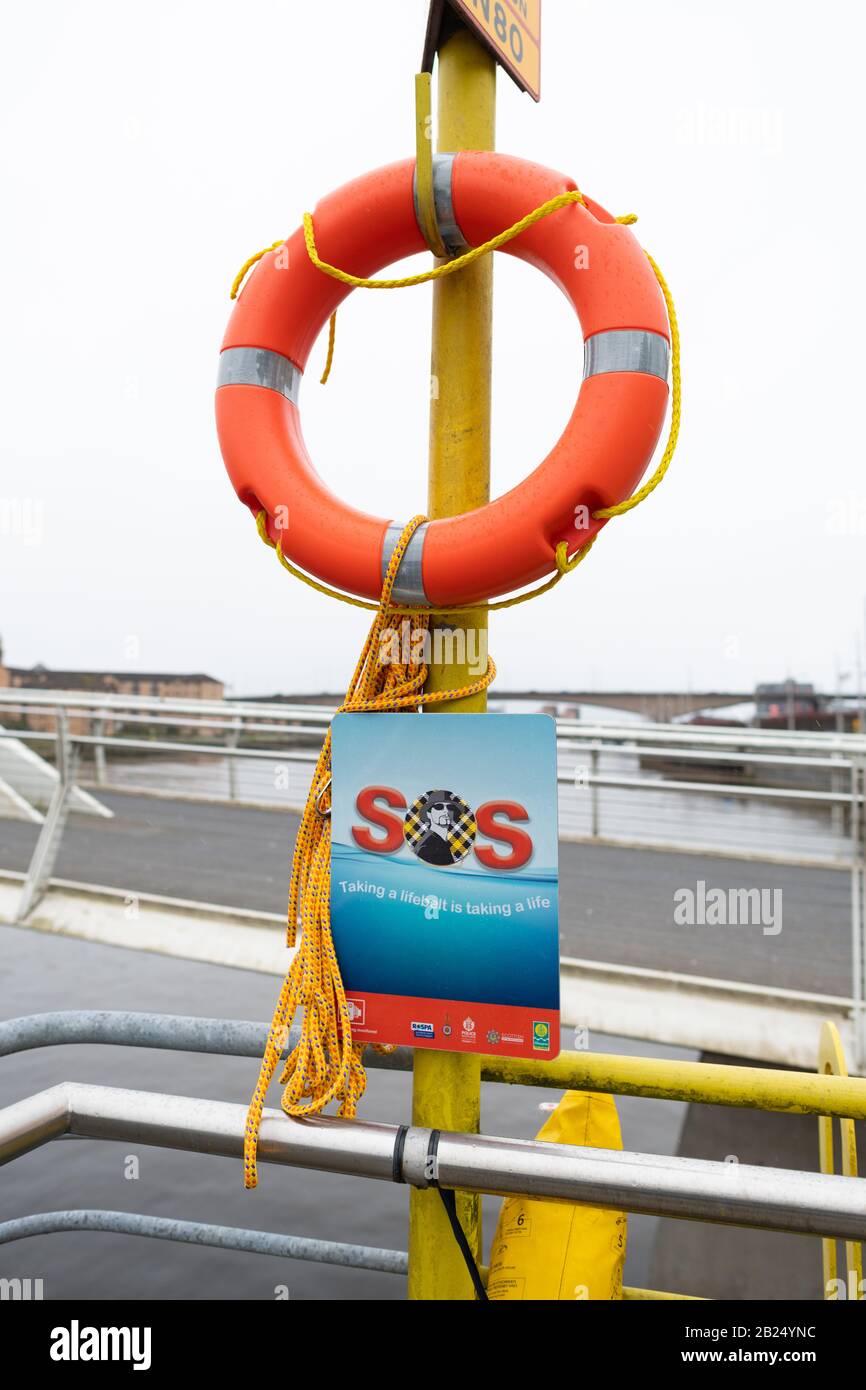 Ceinture de sauvetage à côté de la rivière Clyde, avec une corde jaune, orange et violette distinctive pour dissuader les voleurs après une série de vols, Glasgow, Écosse, Royaume-Uni Banque D'Images