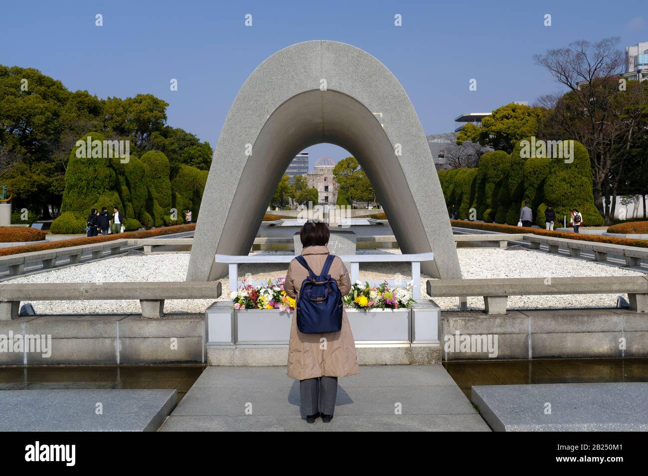 Femme debout devant le cénotaphe pour Les Victimes de la bombe atomique (monument commémoratif d'Hiroshima, ville de la paix) Banque D'Images