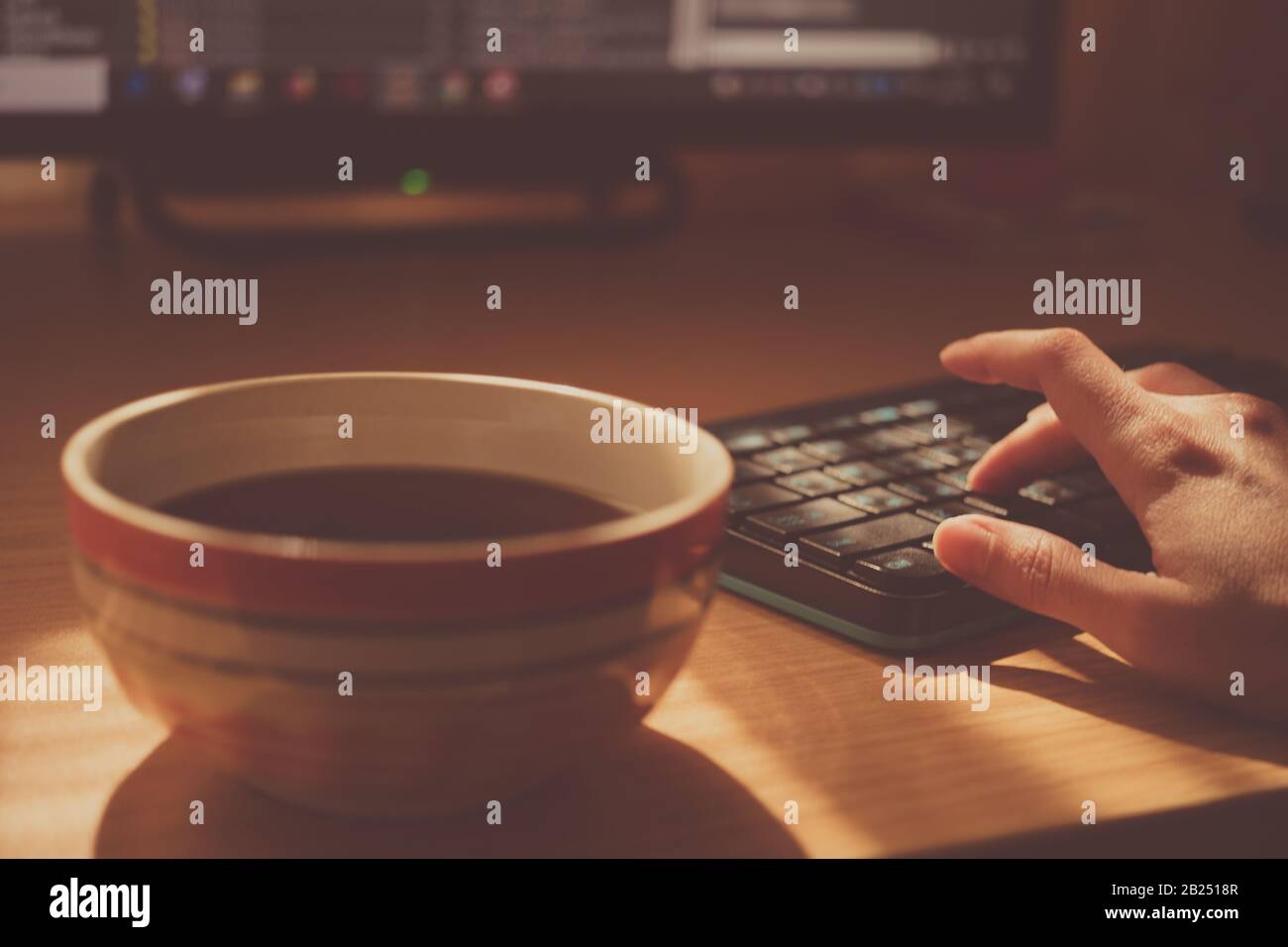 Lieu de travail au bureau avec une tasse de thé et un clavier sur la table. Environnement de travail. Mise au point sélective. Banque D'Images