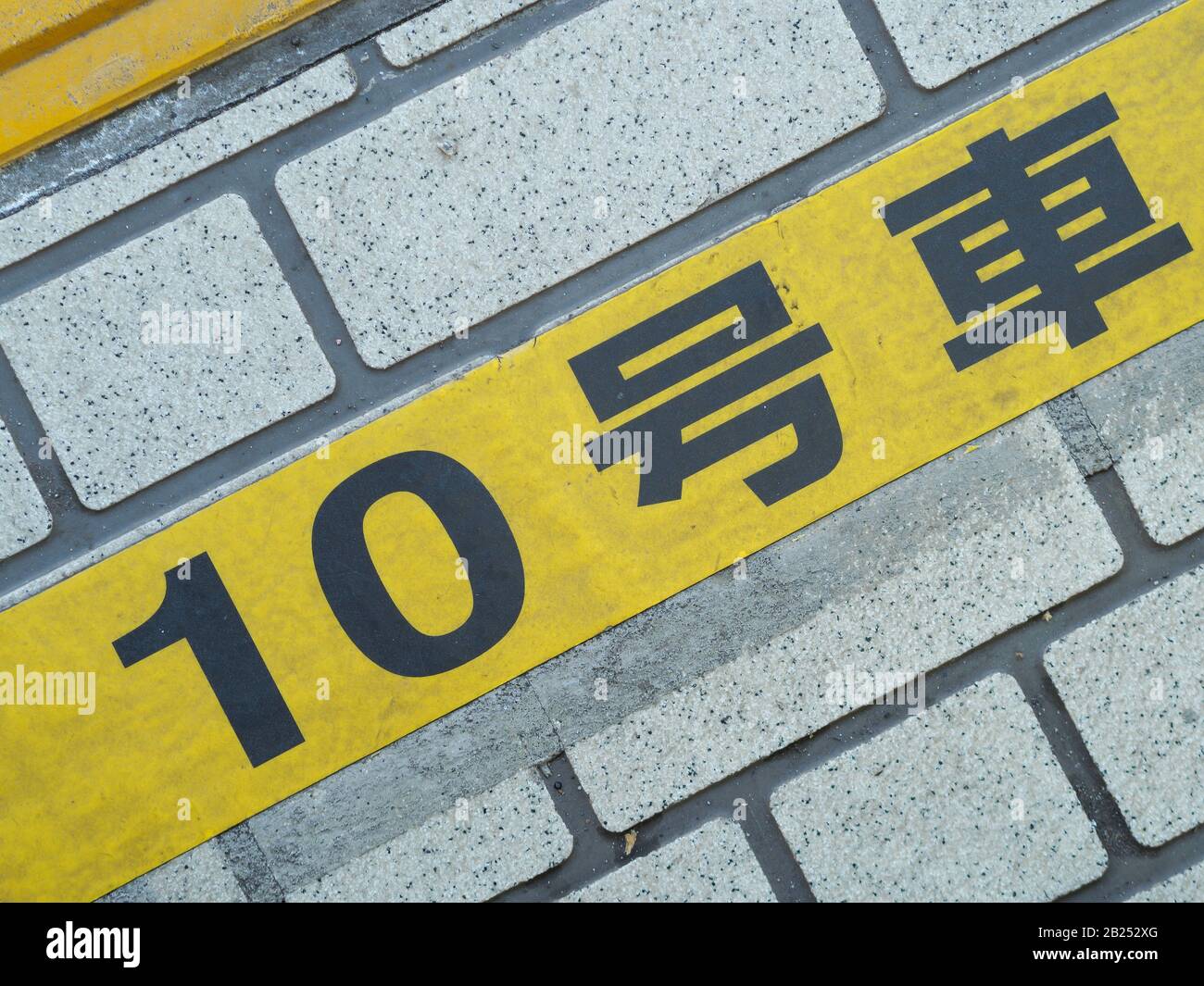 Marqueur de plate-forme à une gare japonaise pour indiquer où faire la file d'attente et où la porte du train s'arrête. Banque D'Images