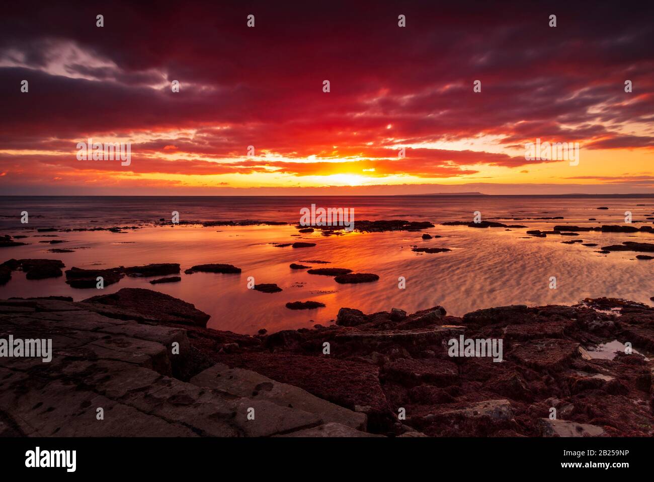 Le ciel s'efface après une tempête de pluie juste assez longtemps pour montrer les nuages rouge et violet profonds au-dessus de la côte jurassique de South Dorset Banque D'Images