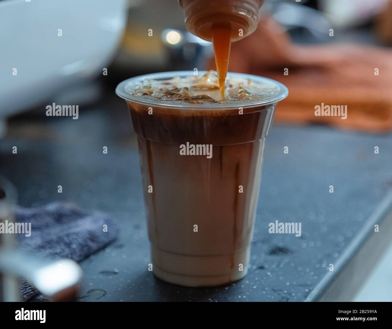 Sur le comptoir dans le café. Café en cours de fait. Il s'agit de macchiato caramel glacé. Des boissons fraîches en été vous permettent de vous rafraîchir et de vous rafraîchir. Banque D'Images