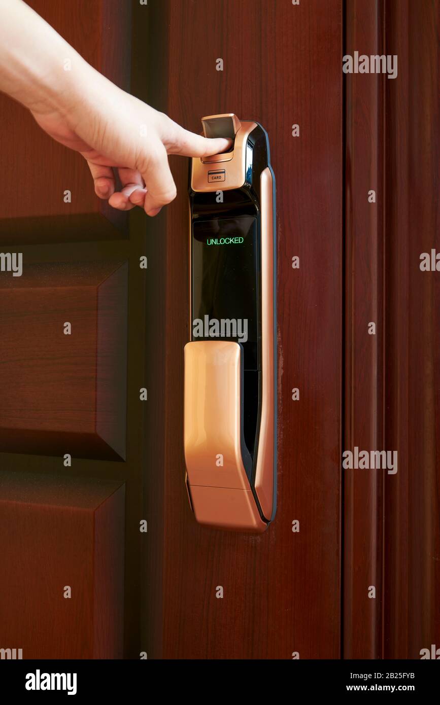 Une personne ouvre une porte avec un verrou de porte intelligent à empreinte  digitale Photo Stock - Alamy