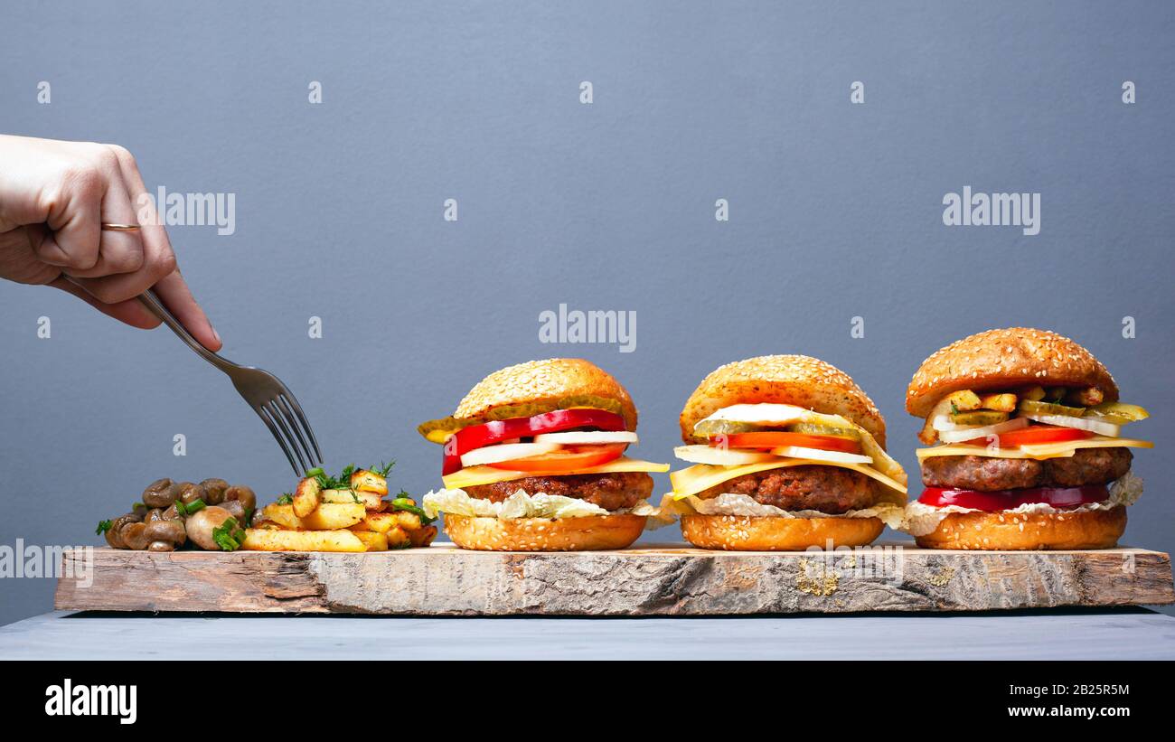 délicieuse cuisine rustique et rapide. jus de 3 hamburgers de pommes de terre et de champignons sur fond gris. mangez avec une fourchette. Banque D'Images