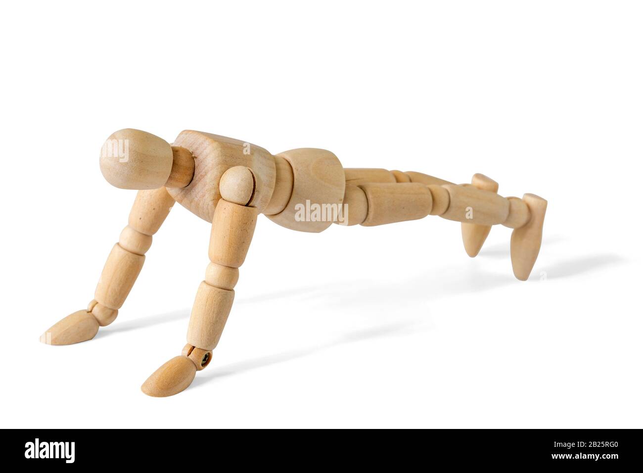 Figurine en bois faisant des push-ups, isolée sur fond blanc Banque D'Images
