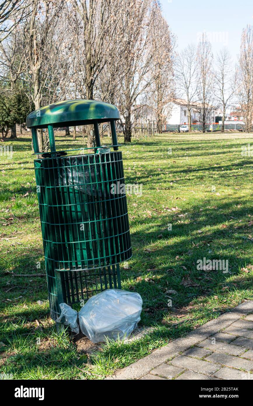 Beaucoup de déchets abandonnés à l'extérieur d'un panier de déchets dans le parc Banque D'Images
