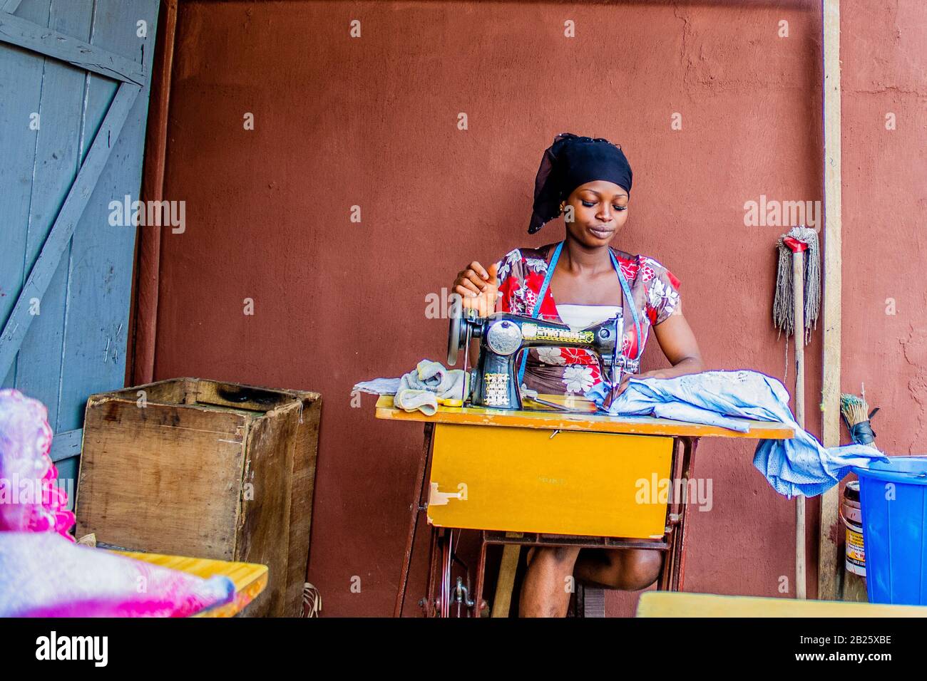 Un tailleur fait des vêtements dans son magasin dans une rue au Nigeria. Banque D'Images