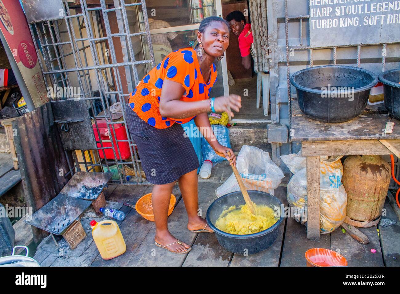 Un vendeur de nourriture fait de l'eba à son magasin dans une rue à Lagos, au Nigeria. Banque D'Images