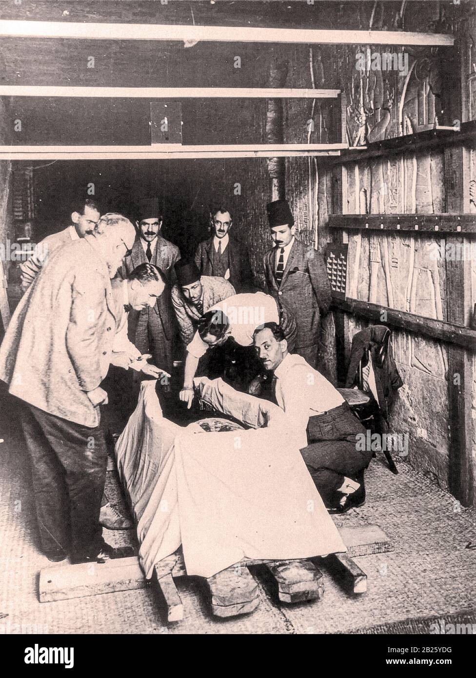 Howard carter, avec loupe, penchant sur la momie du roi Toutankhamun comme la première incision a été faite dans les emballages momie Banque D'Images