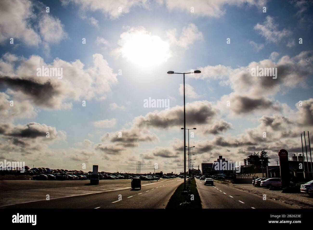 Bâtiments, voitures et réverbères contre le ciel étoilé dans une rue de Lagos, au Nigeria. Banque D'Images