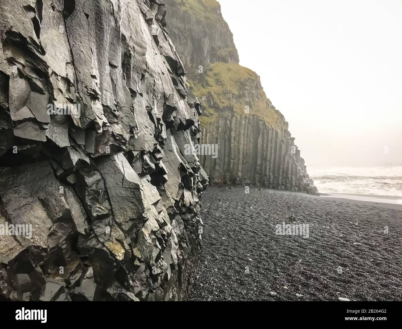 Plage de Reynisfjara à côté des falaises abruptes de basalte Reynisdrangar à côté d'une plage noire Banque D'Images