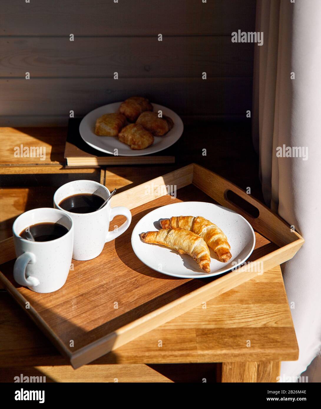 Croissants français, tartes et café noir sur la table dans la chambre de l'hôtel pour le petit-déjeuner Banque D'Images