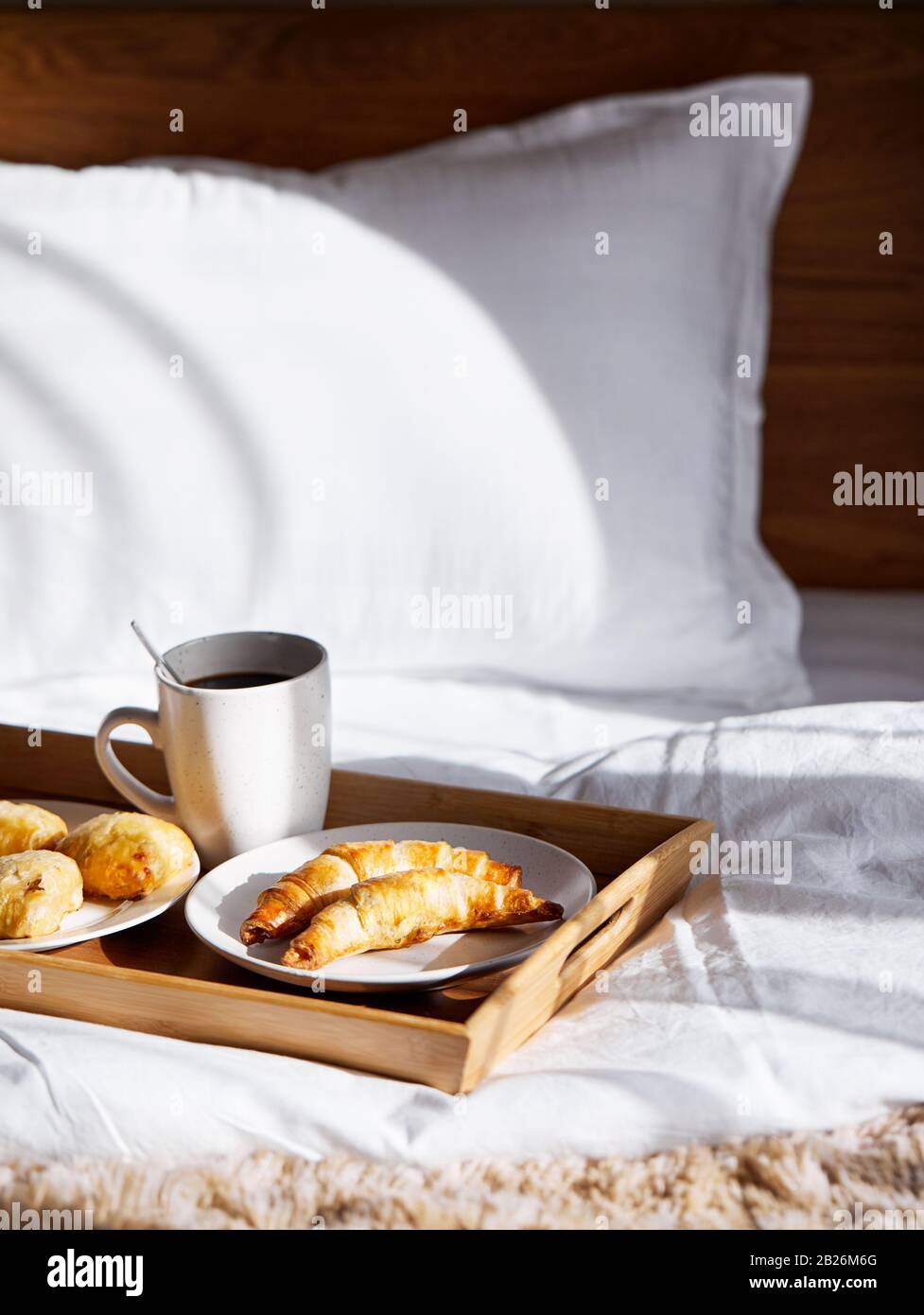 Croissants français et café noir sur le plateau dans la chambre au petit déjeuner Banque D'Images