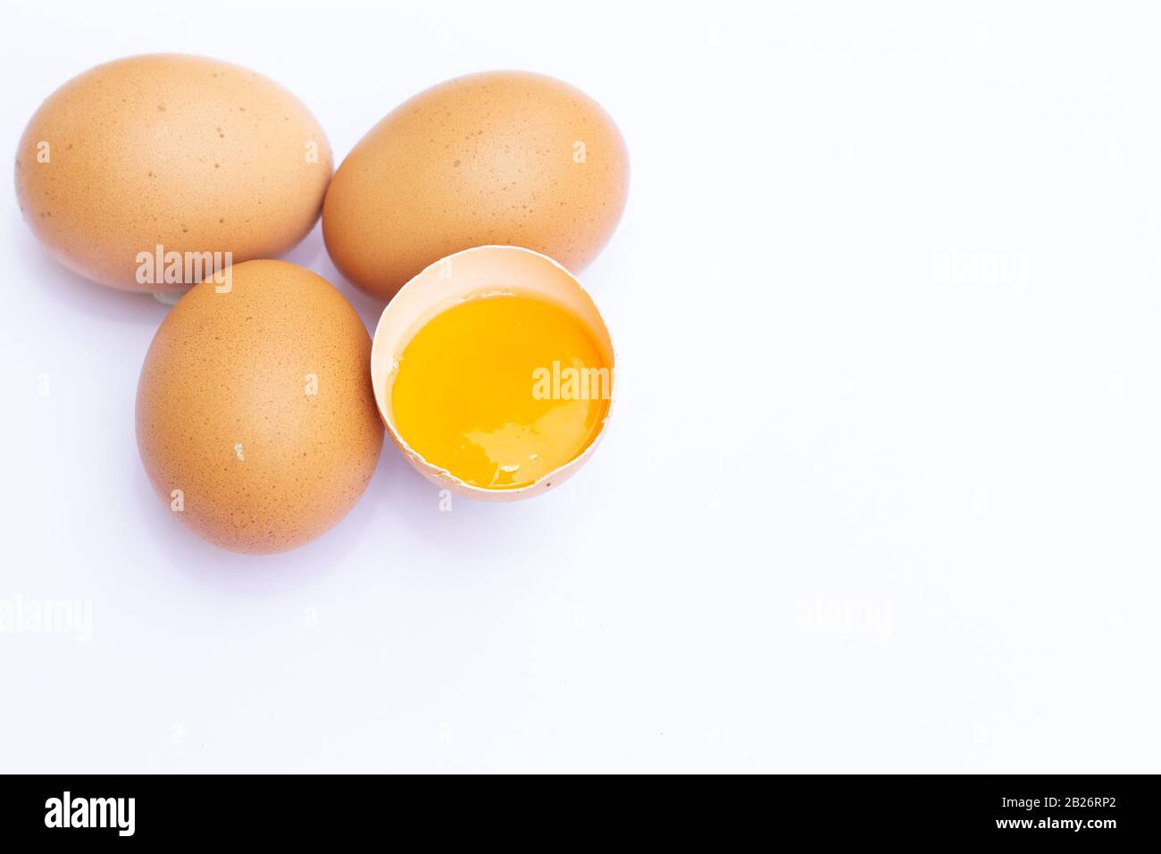 Quatre Oeufs bruns avec un a cassé isolé sur fond blanc Banque D'Images