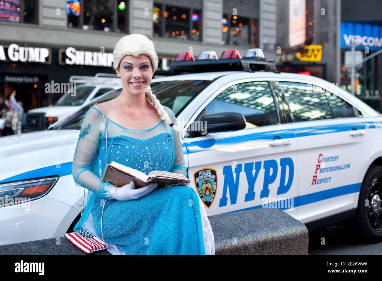 Une jeune femme de broadway a lu une histoire d'un conte de fées devant une voiture de police à New York Banque D'Images