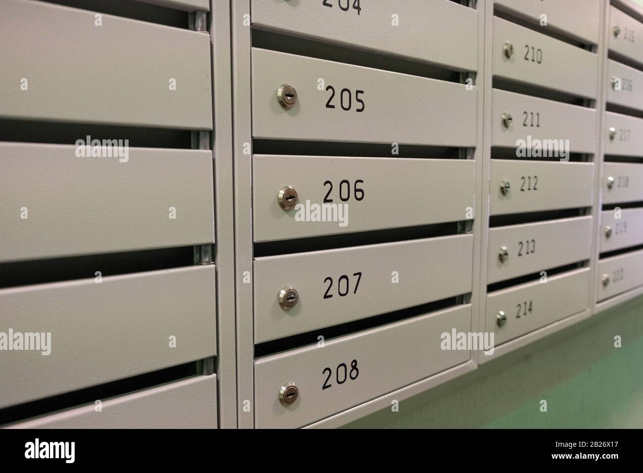 Boîtes aux lettres avec numéros d'appartement dans le couloir d'un bâtiment résidentiel. Boîtes aux lettres pour la livraison de lettres et de journaux Banque D'Images