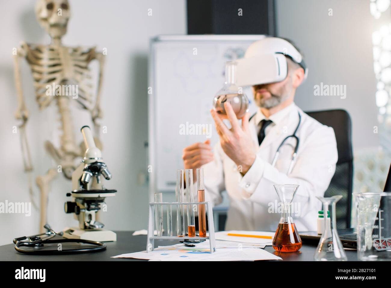 gros plan de l'homme scientifique portant des lunettes vr et tenant la fiole, faisant l'essai en laboratoire clinique. Médecin scientifique portant des lunettes de réalité virtuelle Banque D'Images
