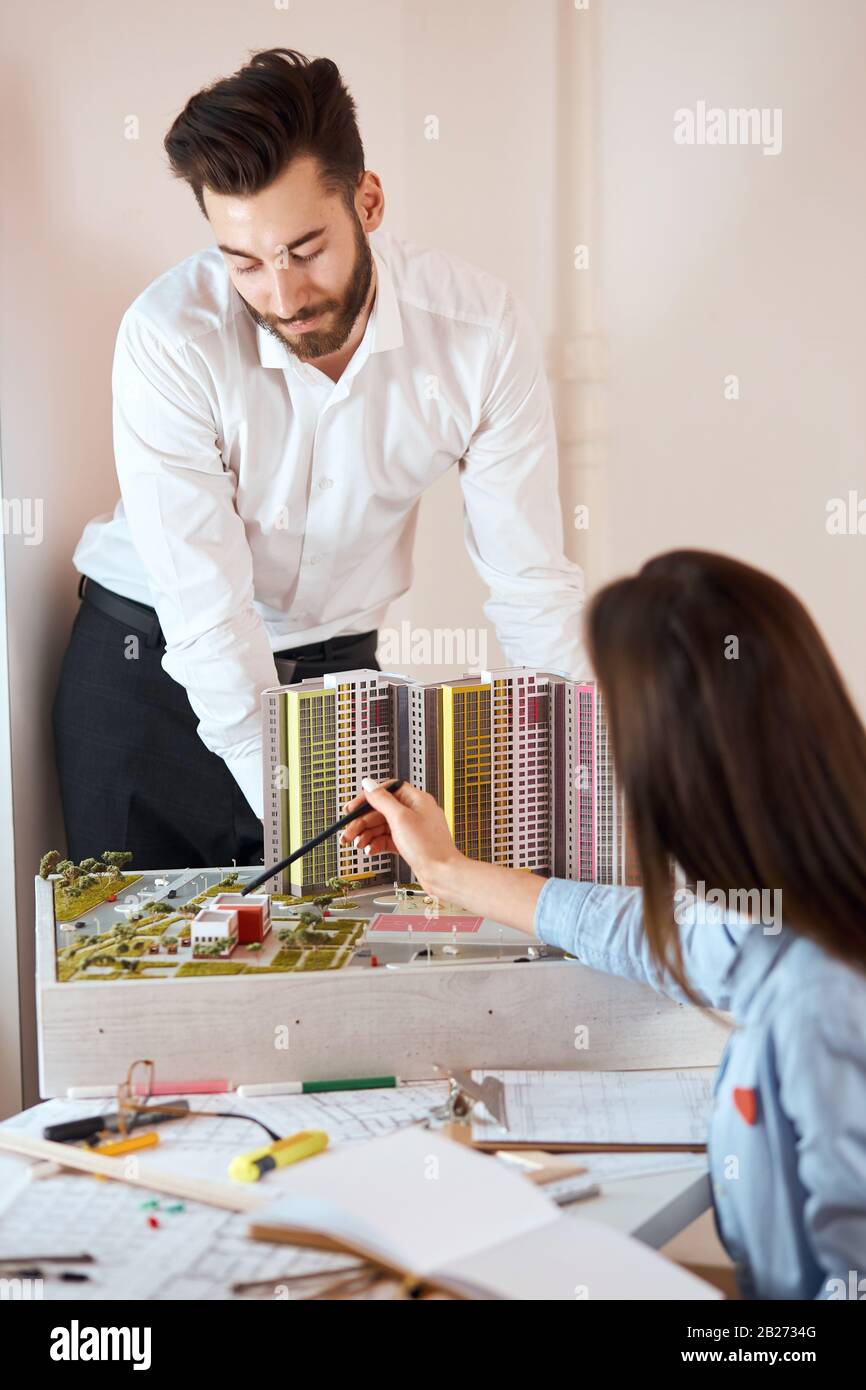 deux collègues intelligents discutant du projet de construction. Jeunes hommes travaillant ensemble sur un nouveau modèle de bâtiment, gros plan vertical shot.architectural, contrainte Banque D'Images