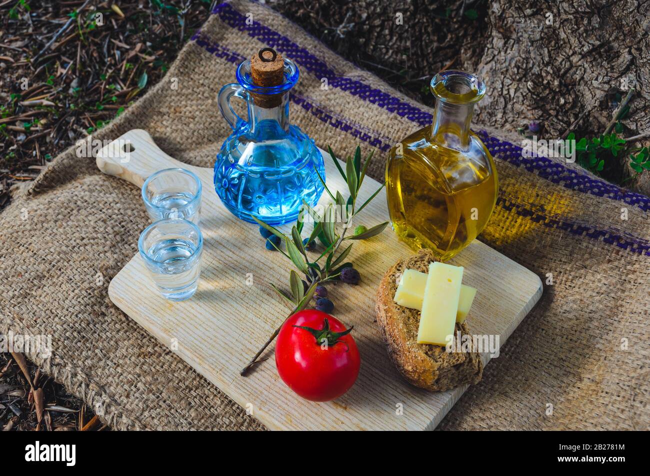 Cuisine crétoise avec huile d'olive vierge, olives, Barley Rusks crétois, fromage local et carafe de raki crétois. Banque D'Images