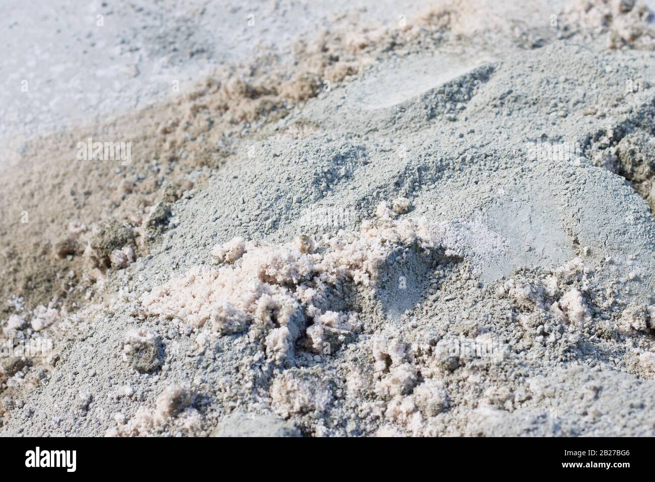 Mélange sec de ciment Portland et de sable de mer partiellement mélangé à une journée chaude et vive Banque D'Images