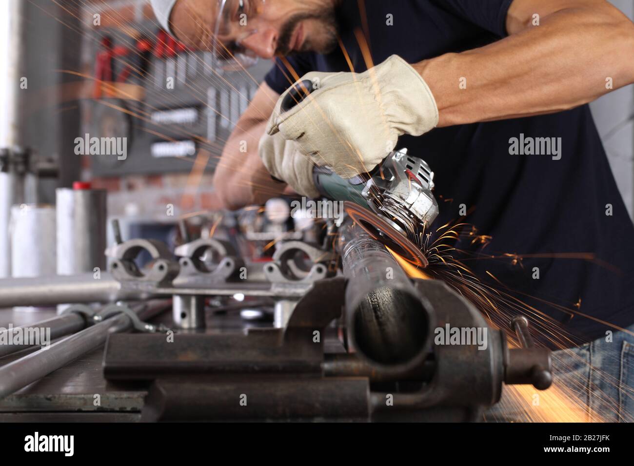 L'homme travail dans l'atelier de maison avec garage, meuleuse d'angle et  de la construction des lunettes, gants de métal ponçage rend gros plan  sparks, bricolage et artisanat concept Photo Stock - Alamy