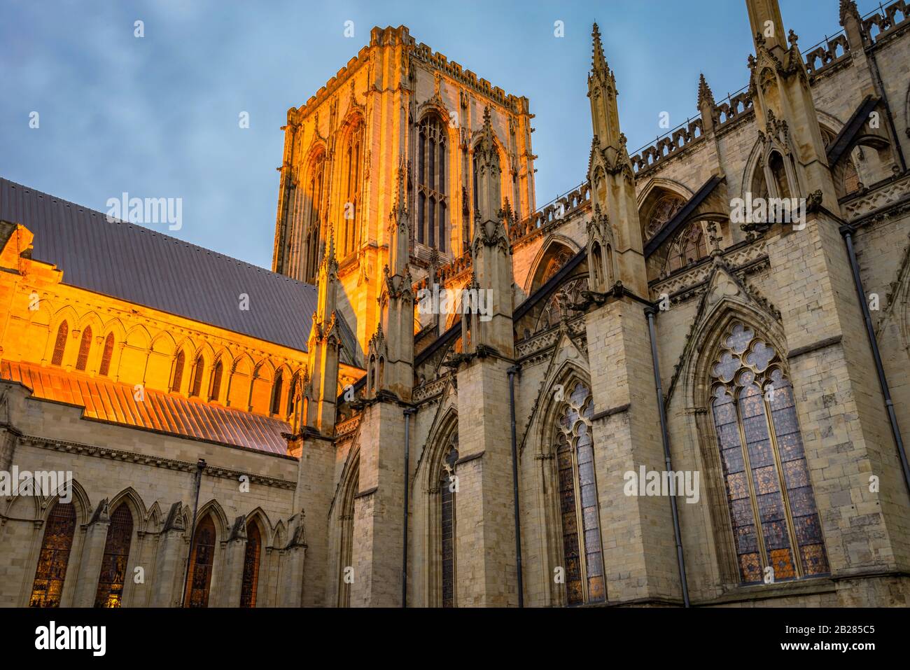 Une section éclairée de York Minster avec son architecture gothique médiévale et sa tour centrale à l'aube. Les vitraux sont allumés. Banque D'Images