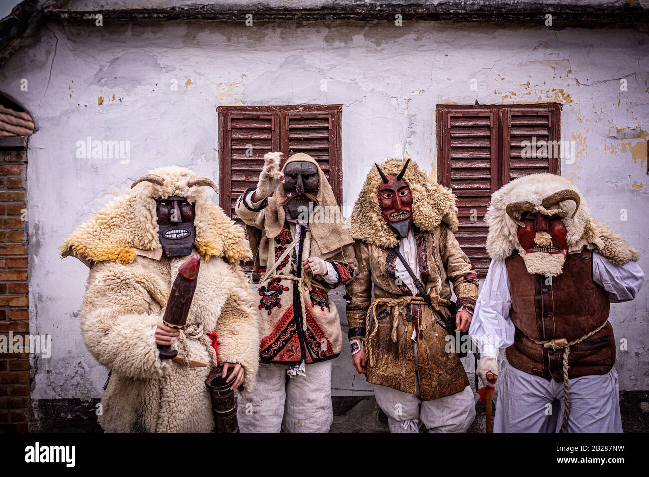 4 hommes vêtus de costume 'buso' sin devant une vieille maison pendant les festivités annuelles de buso à Mohacs, dans le sud de la Hongrie Banque D'Images