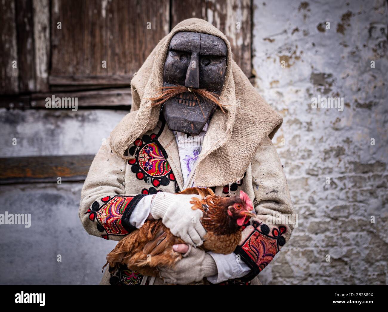 Portrait d'un homme vêtu d'un costume de « buso » tenant un poulet pendant les festivités annuelles du buso à Mohacs, dans le sud de la Hongrie Banque D'Images