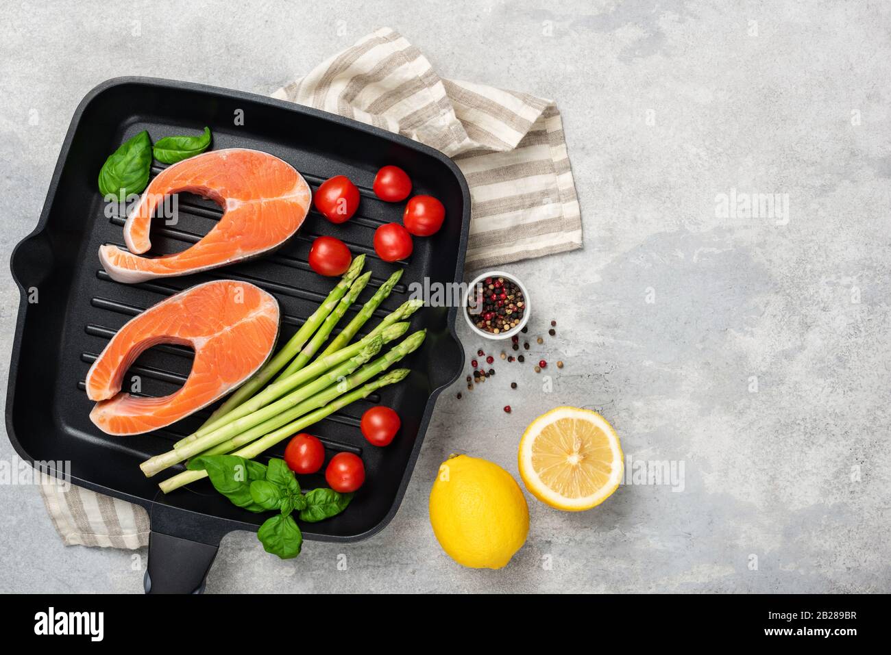 Steaks et légumes de saumon non cuits sur la poêle à gril en métal. Vue de dessus. Ingrédients pour cuisiner des aliments sains riches en oméga 3. Espace de copie pour la conception de recette Banque D'Images