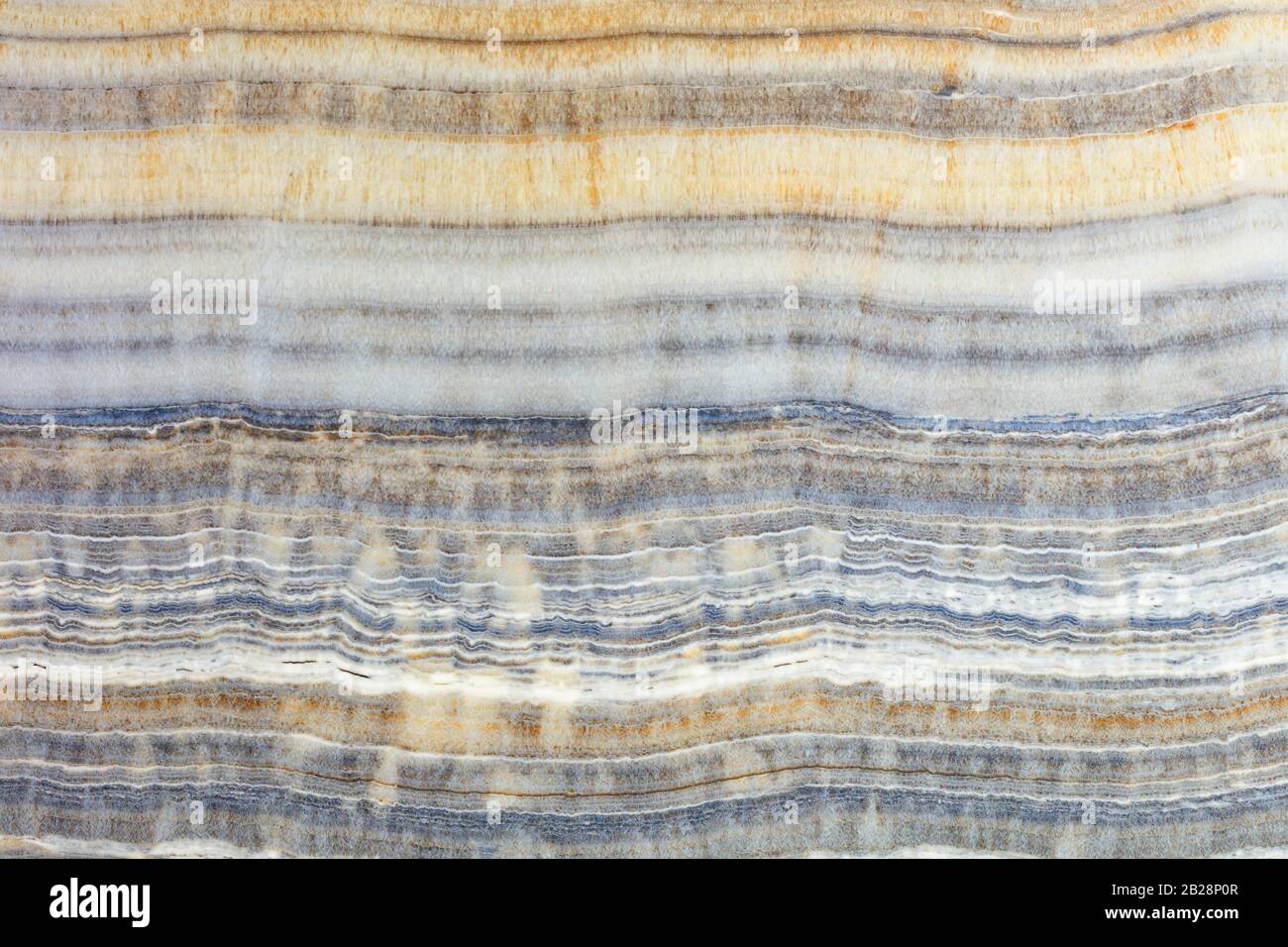 La texture du marbre beige avec des rayures horizontales grises, brunes et beiges ondulées. Surface polie. Banque D'Images