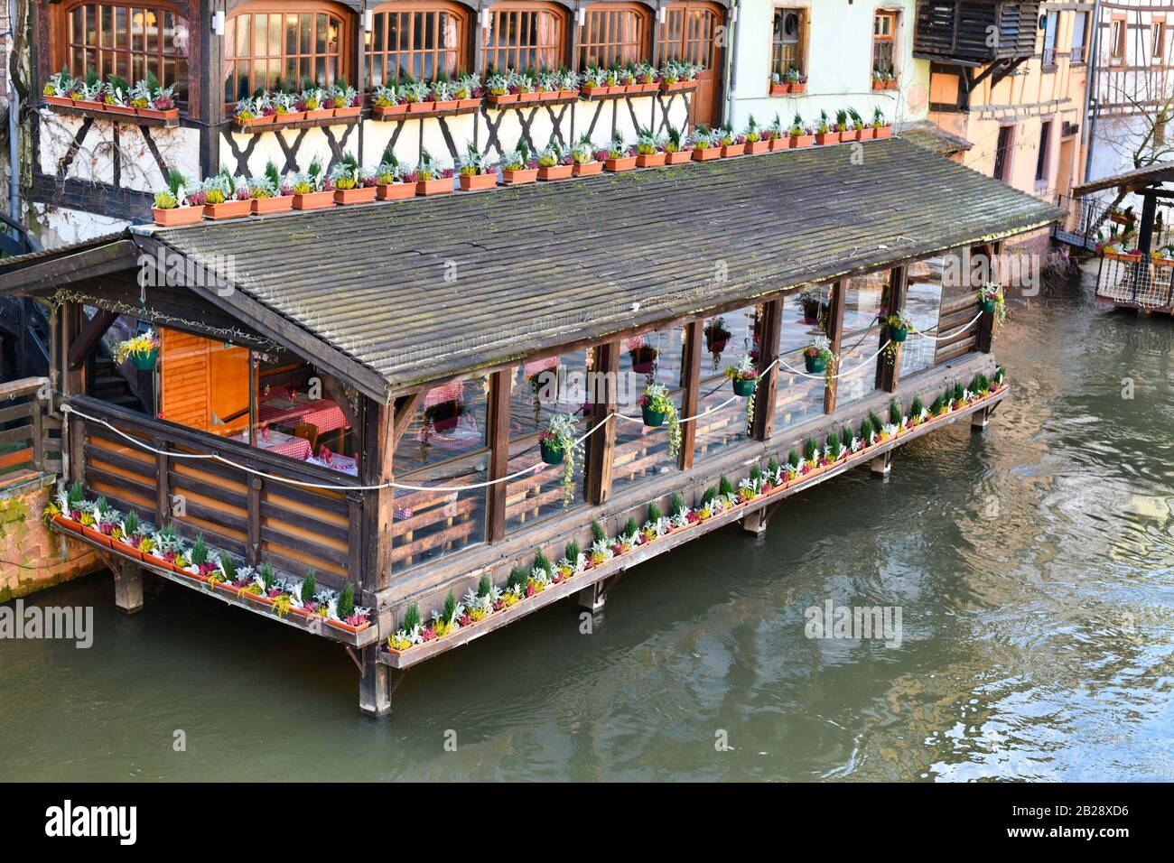 France, Restaurant dans de vieux bâtiments sur pilotis debout dans la rivière III dans le quartier historique de la petite France de Strasbourg Banque D'Images