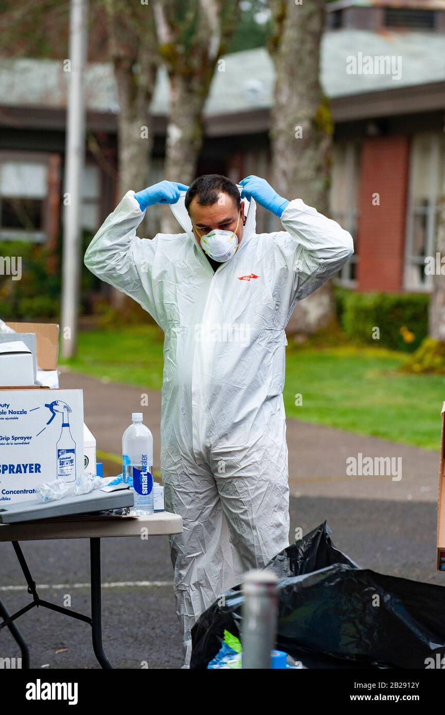 Les travailleurs ont des vêtements de protection et des masques avant d'entrer à l'école primaire de Forest Hills dans le lac Oswego, Oregon. Les autorités sanitaires de l'Oregon ont identifié un membre du personnel scolaire comme ayant un test positif de COVID-19 Ccoronavirus, vérifié par les Centres de contrôle des maladies à Atlanta. Lake Oswego School District Superentendent, le Dr Lora de la Cruz a déclaré que le "nettoyage en profondeur" de l'école est entrepris par mesure de précaution. Banque D'Images