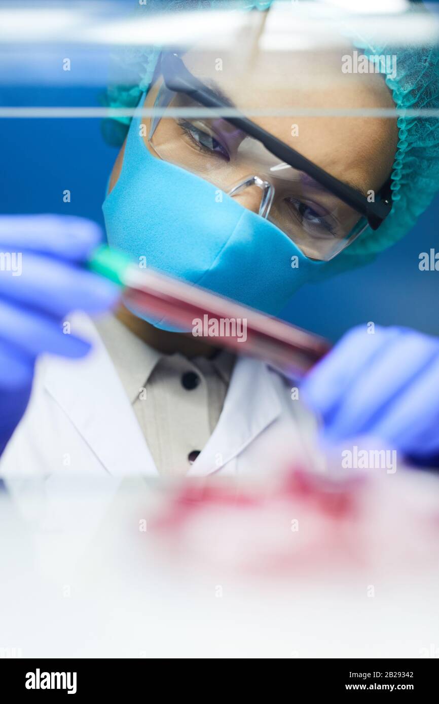 Portrait d'une scientifique féminine tenant un tube à essai avec un échantillon sanguin tout en travaillant sur la recherche en laboratoire, espace de copie Banque D'Images