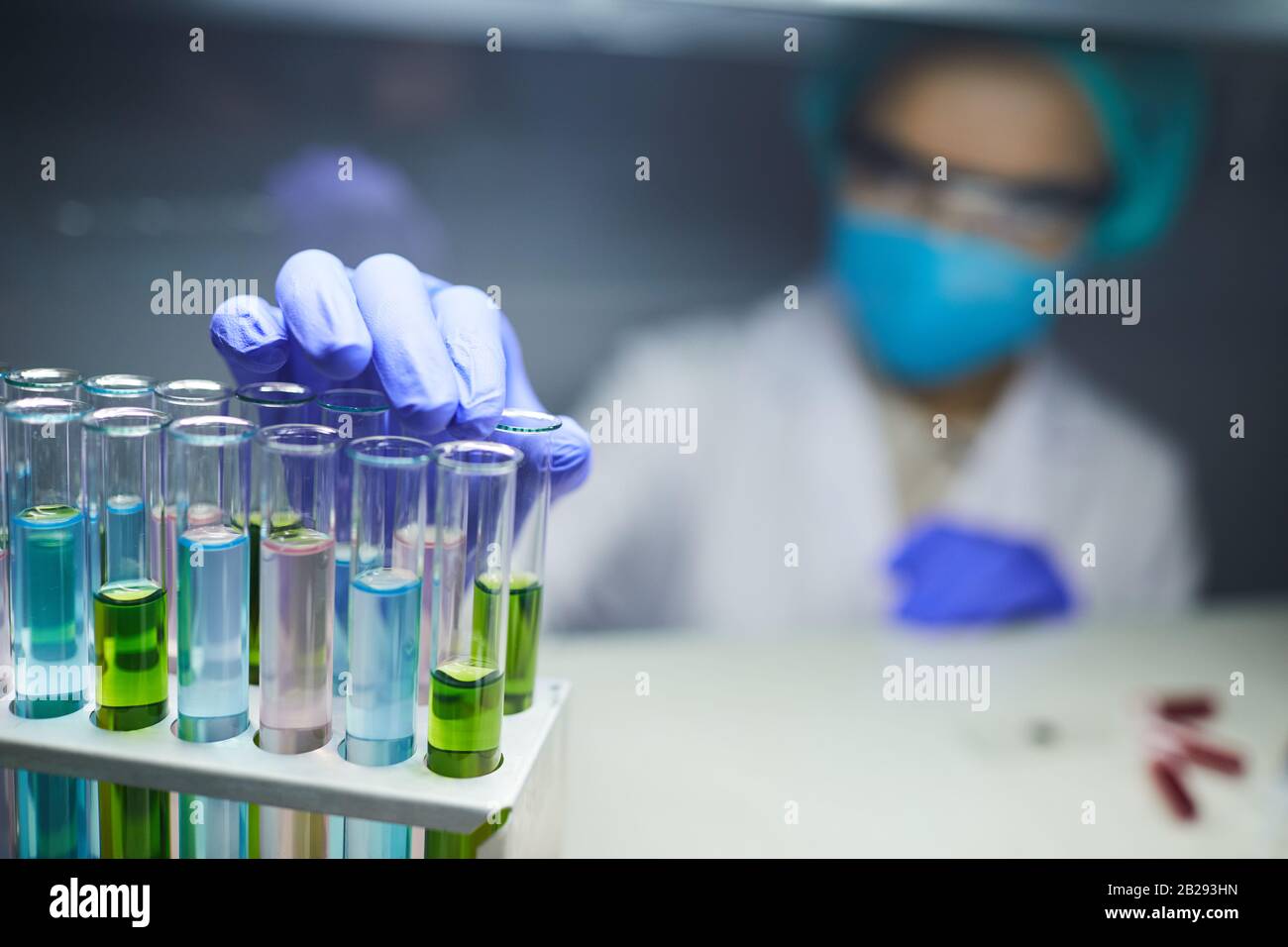 Gros plan de scientifique prenant un tube à essai avec du liquide coloré tout en travaillant sur la bio-recherche en laboratoire, espace de copie Banque D'Images