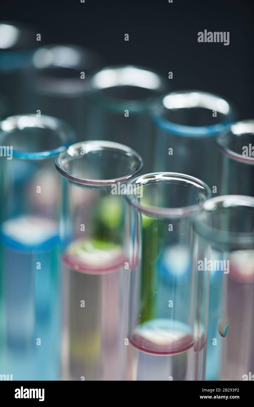 Arrière-plan extrêmement rapproché des tubes à essai avec un liquide coloré sur la table dans le laboratoire de recherche, espace de copie Banque D'Images