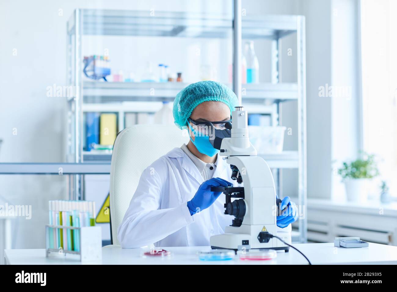 Portrait de la scientifique féminine regardant au microscope tout en travaillant sur la recherche en laboratoire médical, espace de copie Banque D'Images