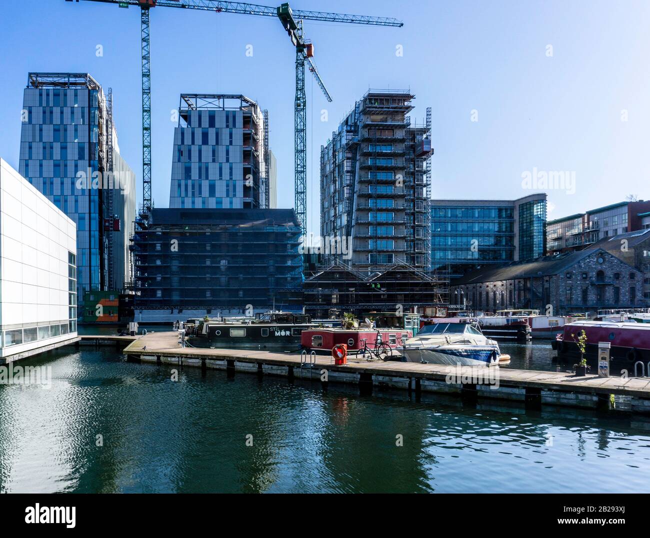 Les grandes maisons de Canal Dock à Grand Canal Dock, Dublin, Irlande, éclipsé par la construction des nouveaux bureaux Google sur le site de Bolands Mills. Banque D'Images