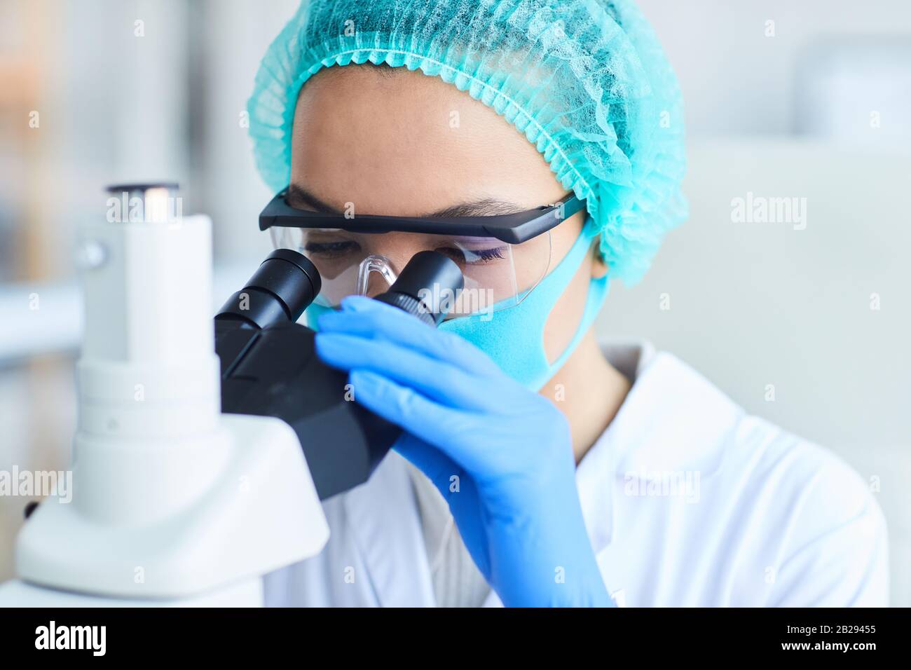 Gros plan portrait de la scientifique féminine regardant au microscope tout en travaillant sur la recherche en laboratoire médical, espace de copie Banque D'Images