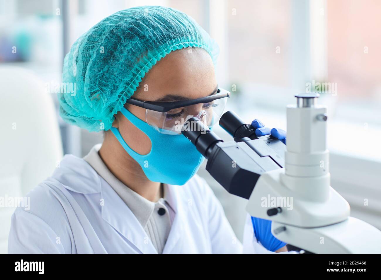 Portrait de la femme scientifique regardant au microscope tout en travaillant sur la recherche en laboratoire médical, espace de copie Banque D'Images